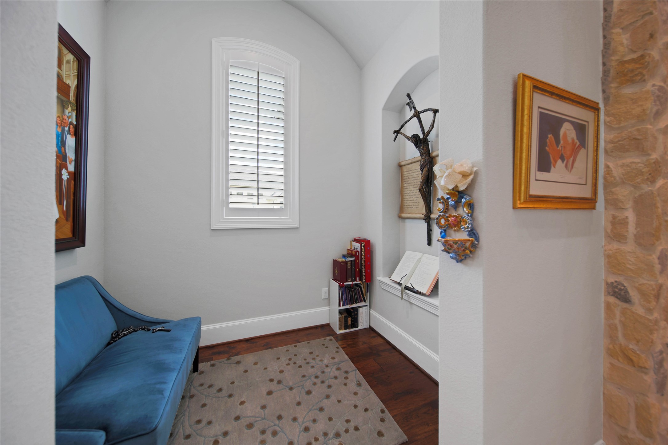 24718 Shadow Pond Spring, TX 77389 - Photo 19 of 49 Charming reading nook with a cozy blue sofa, elegant hardwood floors, and stylish decor, perfect for relaxation and contemplation.