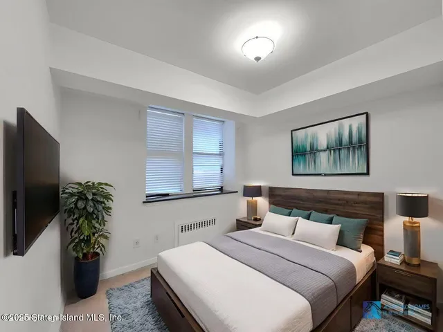 a bedroom with a bed and a potted plant