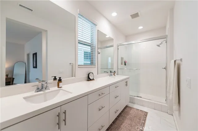 a bathroom with a shower sink and a mirror