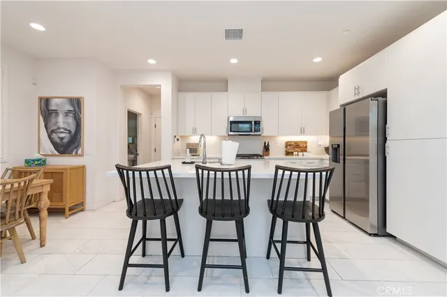 a kitchen with a table chairs refrigerator and cabinets
