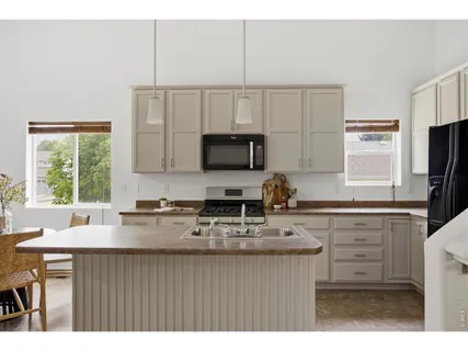 a kitchen with kitchen island a sink appliances cabinets and a counter top space