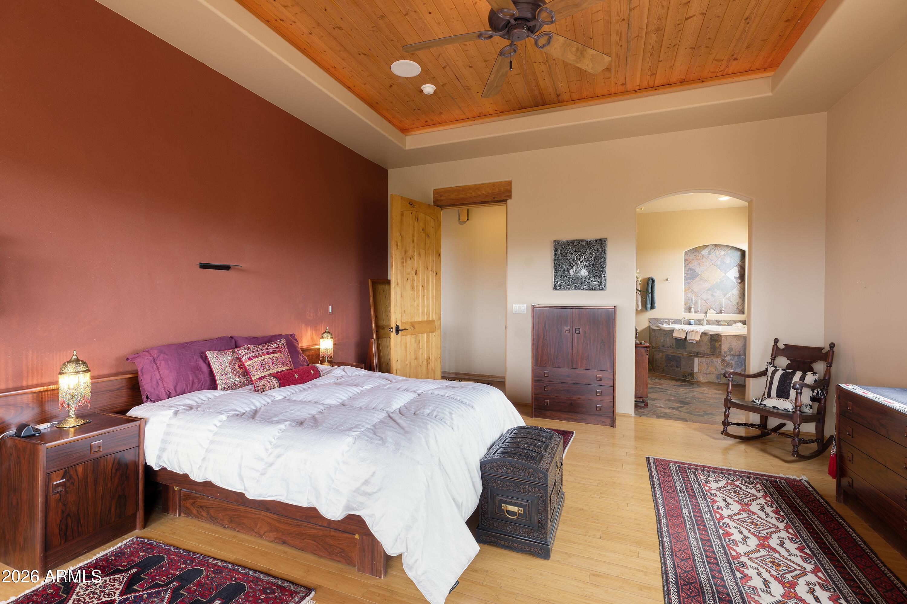 13906 East Montello Road Scottsdale, AZ 85262 - Photo 31 of 110 a spacious bedroom with a bed a chandelier and a rug