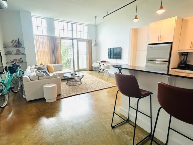 a living room with fireplace furniture and a large window