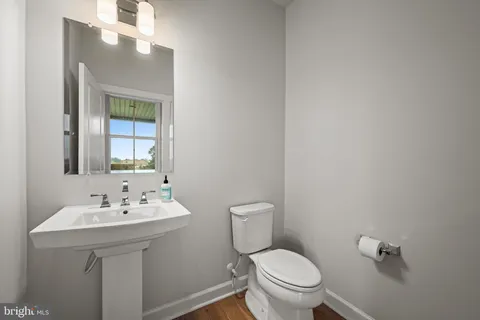 a bathroom with a sink mirror and toilet