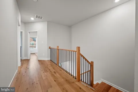 a view of a hallway with wooden floor and entryway