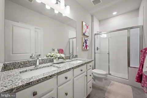 a bathroom with a granite countertop sink a toilet and a mirror