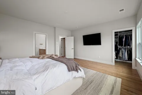 a spacious bedroom with a bed and a flat screen tv