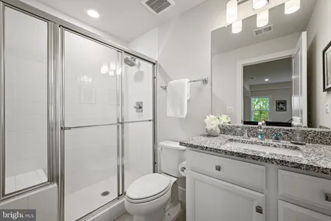 a bathroom with a granite countertop sink toilet and shower