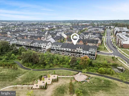 an aerial view of a residential houses with outdoor space and trees