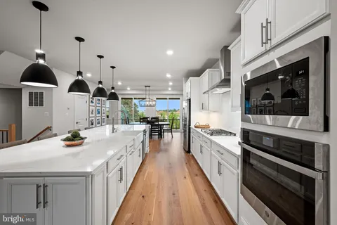 a kitchen with kitchen island a stove and a wooden floors