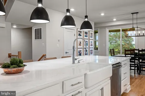 a kitchen with stainless steel appliances a dining table chairs and white cabinets