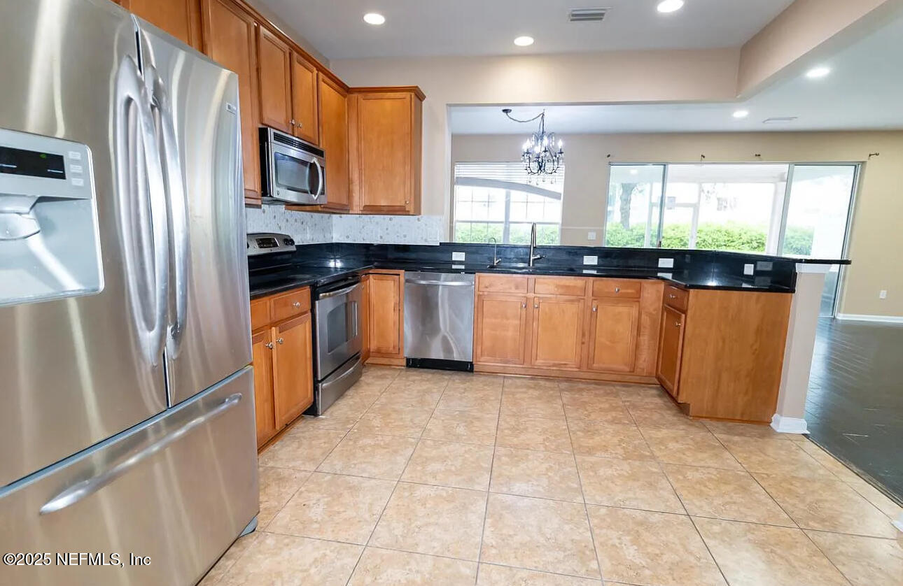 4204 Metron Drive Jacksonville, FL 32216 - Photo 7 of 24 a large kitchen with stainless steel appliances granite countertop a refrigerator and a sink