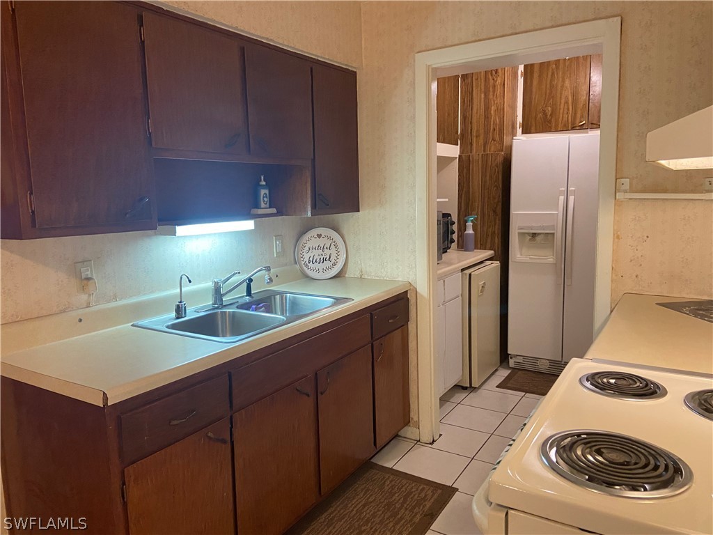 119 Apache Street Lehigh Acres, FL 33936 - Photo 14 of 29 a utility room with a sink a washer and dryer