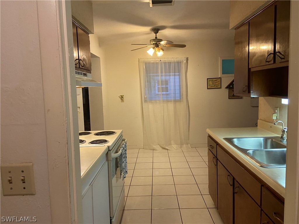 119 Apache Street Lehigh Acres, FL 33936 - Photo 16 of 29 a kitchen with stainless steel appliances granite countertop a sink and a refrigerator