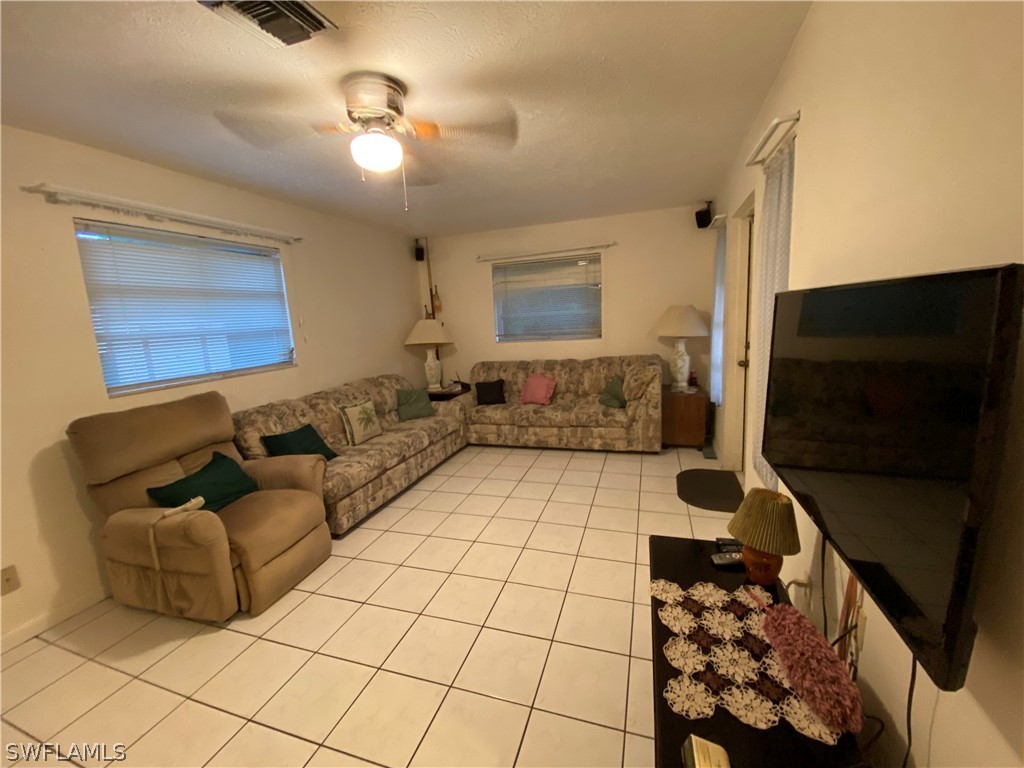 119 Apache Street Lehigh Acres, FL 33936 - Photo 18 of 29 a living room with furniture and a flat screen tv