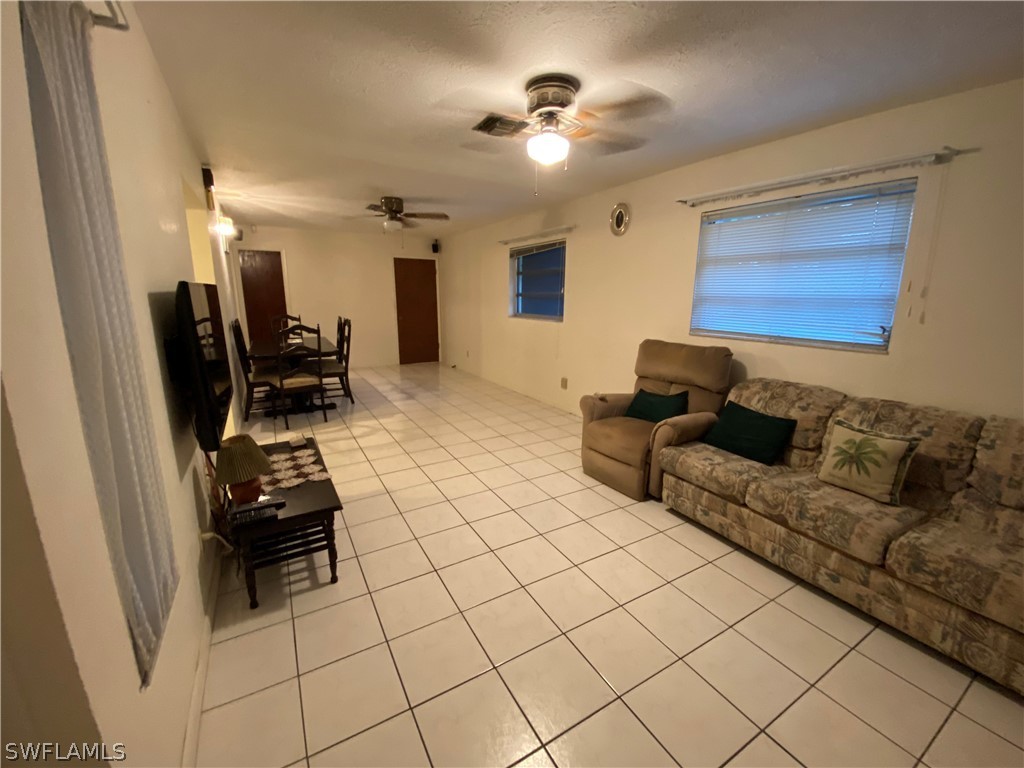 119 Apache Street Lehigh Acres, FL 33936 - Photo 19 of 29 a living room with furniture and a flat screen tv