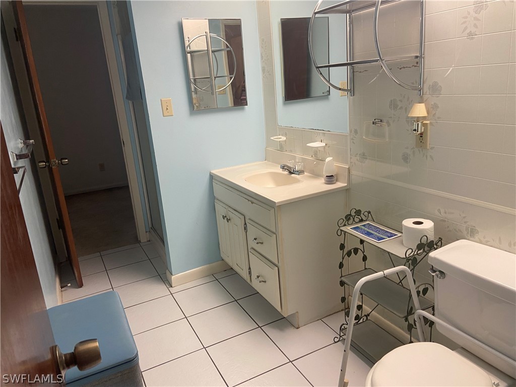 119 Apache Street Lehigh Acres, FL 33936 - Photo 24 of 29 a bathroom with a sink a toilet and mirror