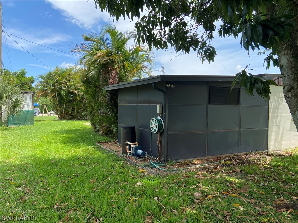 119 Apache Street Lehigh Acres, FL 33936 - Photo 5 of 29 a backyard of a house with table and chairs