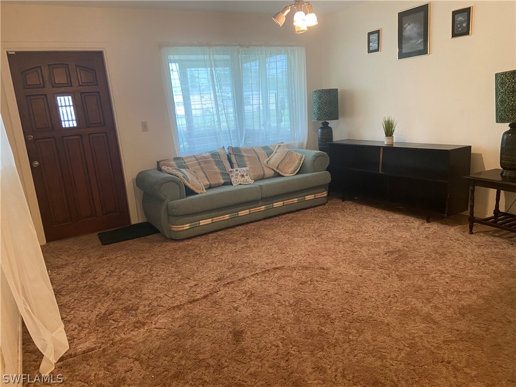 119 Apache Street Lehigh Acres, FL 33936 - Photo 10 of 29 a living room with furniture and a potted plant