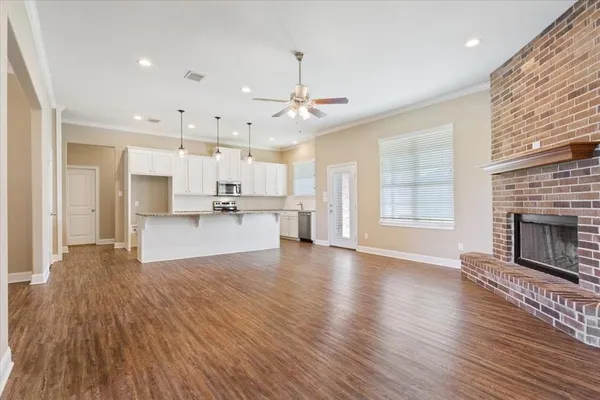 a view of kitchen with livingroom and fireplace wooden floor