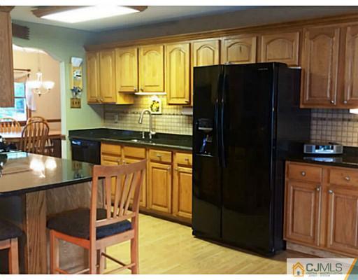 8 Winant Road Kendall Park, NJ 08824 - Photo 3 of 23 a kitchen with granite countertop a refrigerator and wooden cabinets