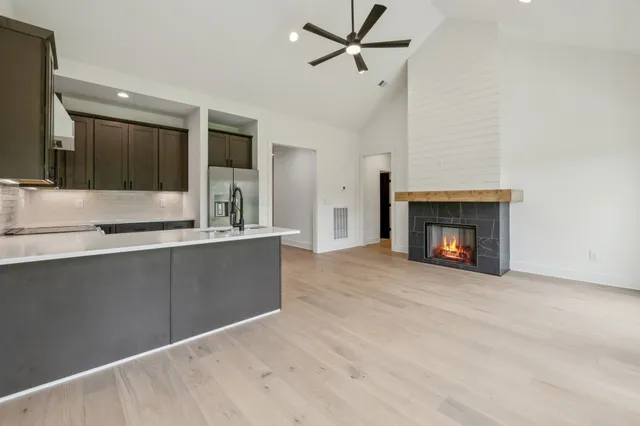 a view of an empty room with a fireplace and a window