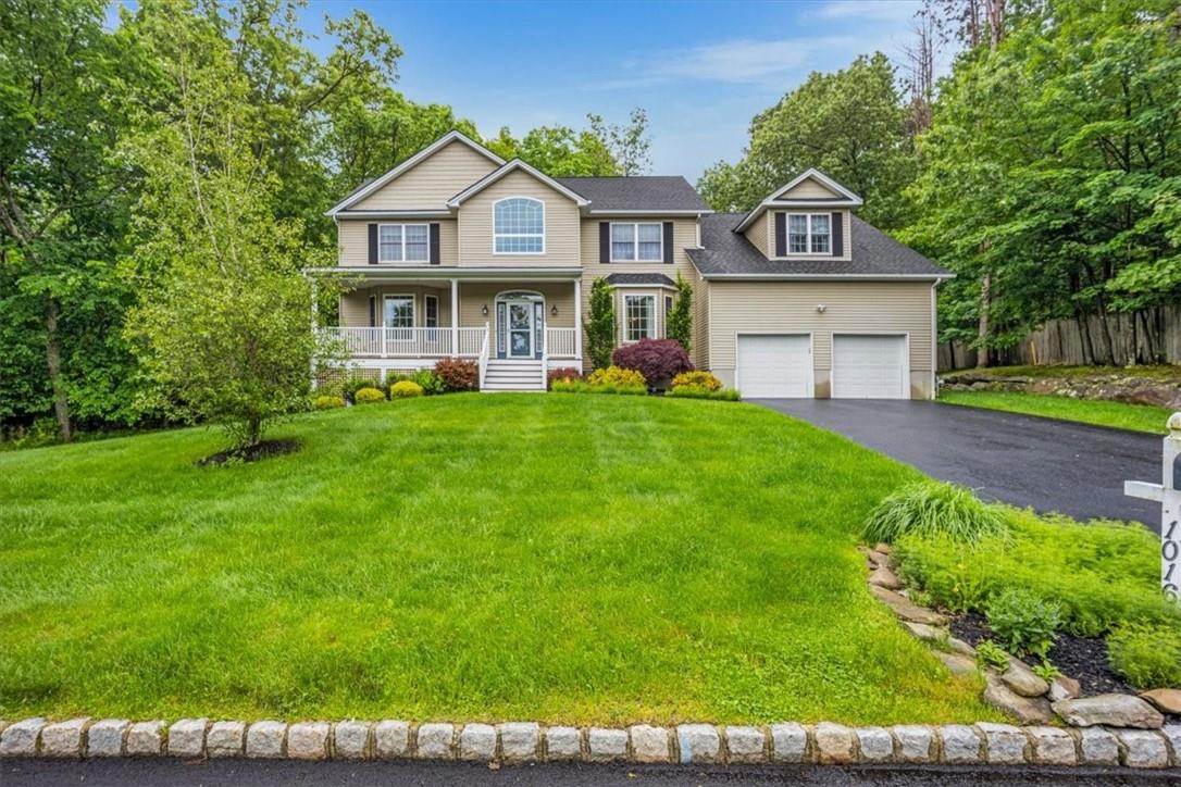 a view of a house with a big yard and large trees