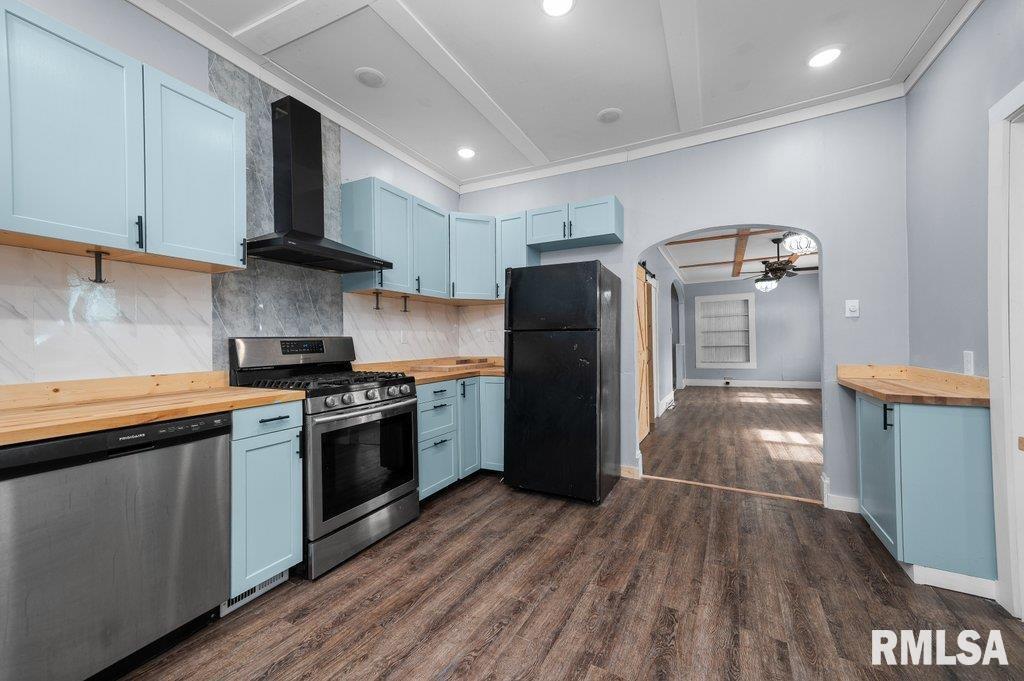 210 North 5th Street Clinton, IA 52732 - Photo 12 of 35 a kitchen with stainless steel appliances granite countertop a refrigerator a stove and a sink with wooden floors