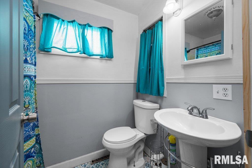 210 North 5th Street Clinton, IA 52732 - Photo 14 of 35 a bathroom with a sink and a toilet