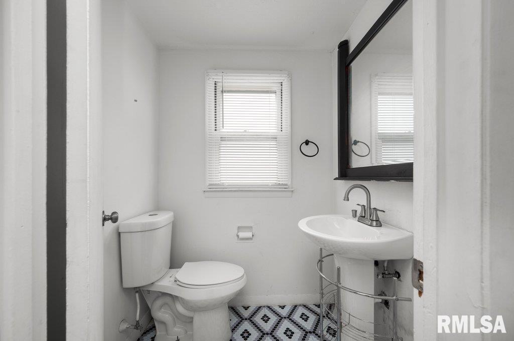 210 North 5th Street Clinton, IA 52732 - Photo 23 of 35 a bathroom with a sink toilet and mirror