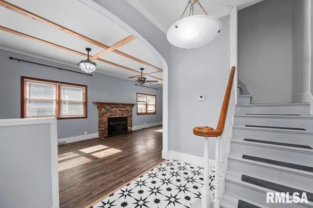 a view of a livingroom with wooden floor a ceiling fan and a window