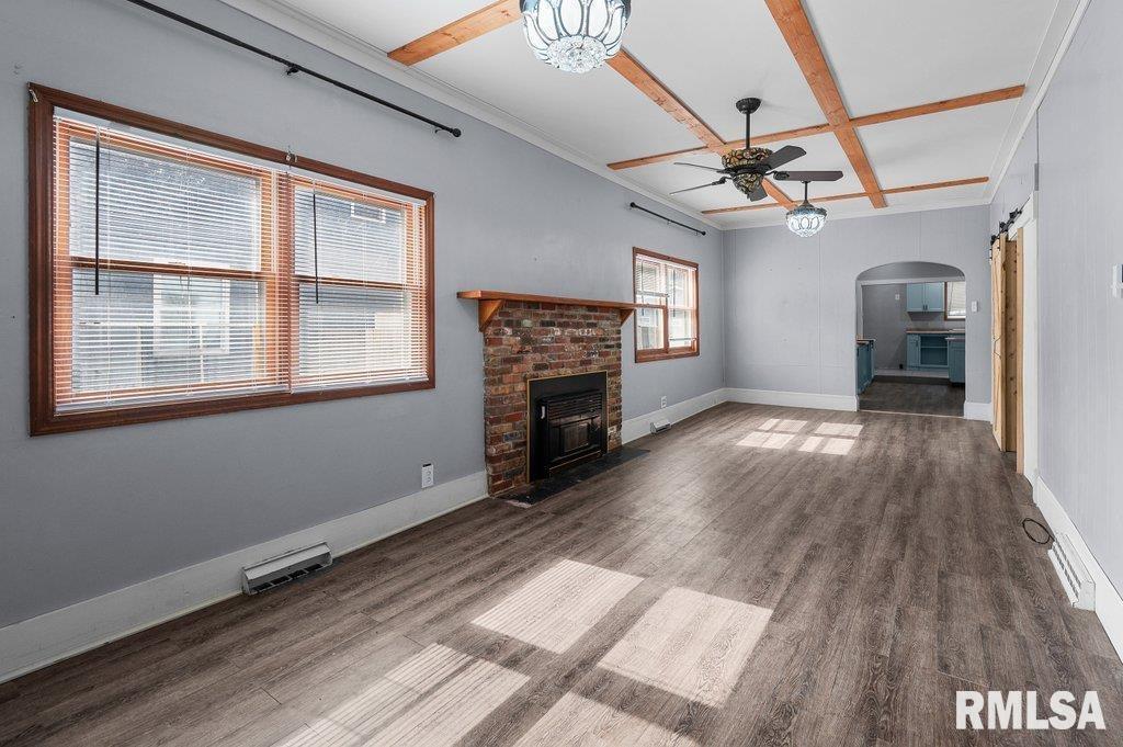 210 North 5th Street Clinton, IA 52732 - Photo 5 of 35 a view of a livingroom with wooden floor a ceiling fan and windows