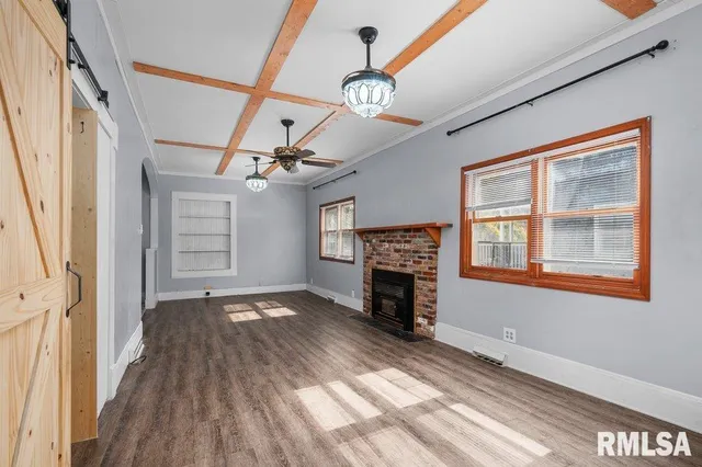 a view of an empty room with a fireplace and a window