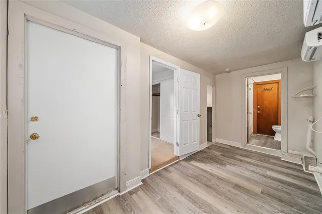 a view of a hallway with wooden floor and closet area