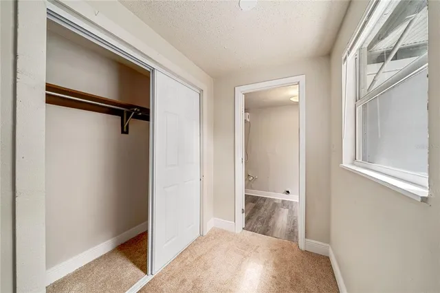 a view of a hallway with closet and wooden floor