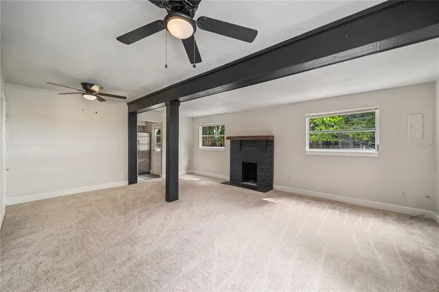 an empty room with windows and ceiling fan