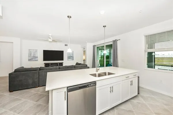 a living room with lots of furniture and kitchen view