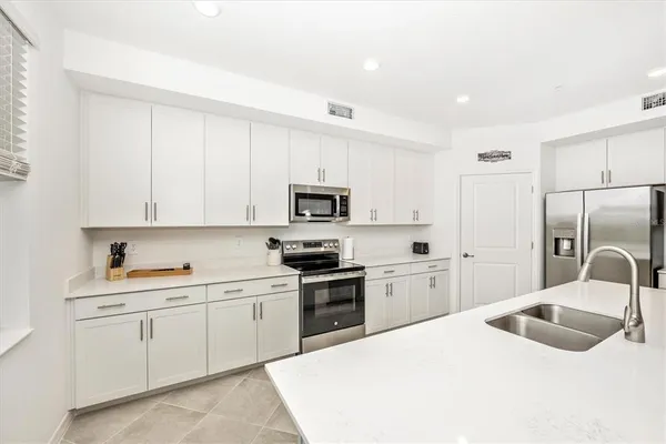 a living room with furniture kitchen area and a kitchen view