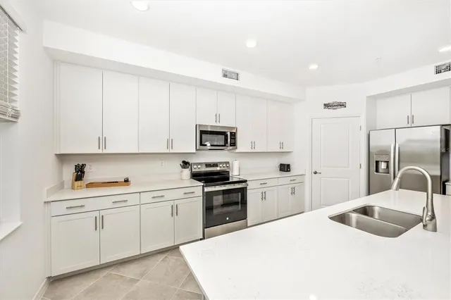 a living room with furniture kitchen area and a kitchen view
