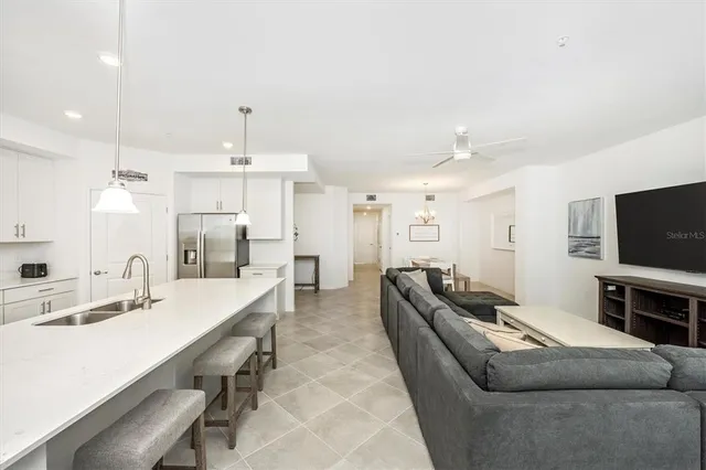 a spacious bedroom with a bed a couch and a chandelier