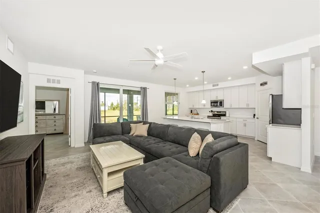a bedroom with a large bed and a chandelier fan