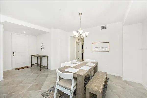 a kitchen with stainless steel appliances a sink a stove a refrigerator with white cabinets and wooden floor