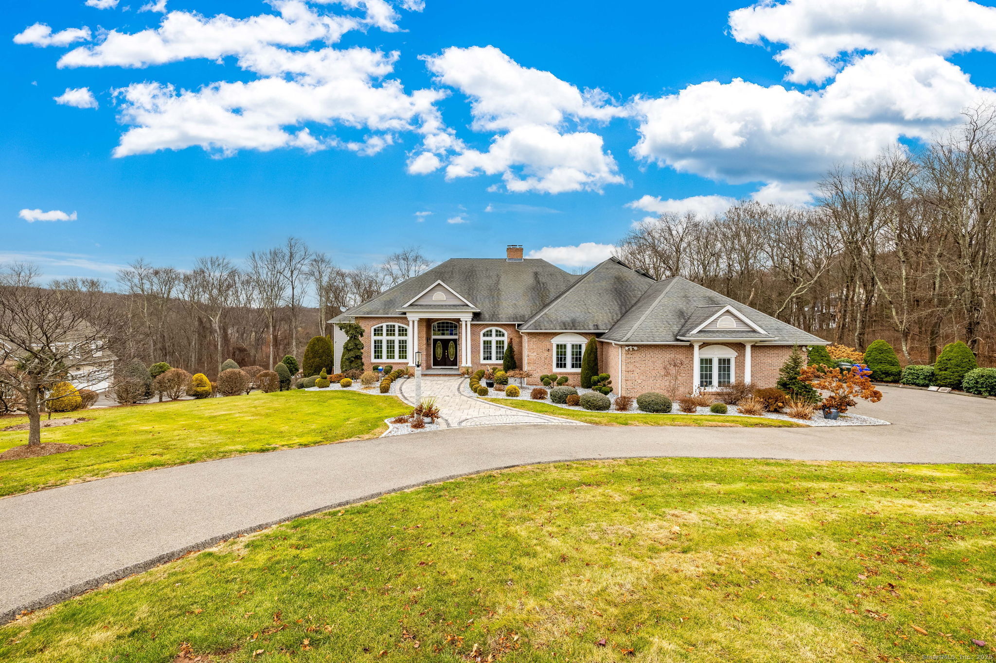 a front view of a house with a yard and lake view