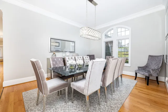 a view of a dining room with furniture a chandelier and wooden floor