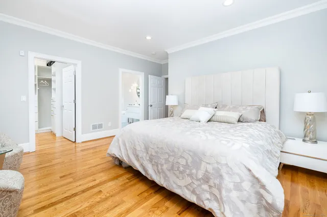 a spacious bedroom with a bed and a lamp