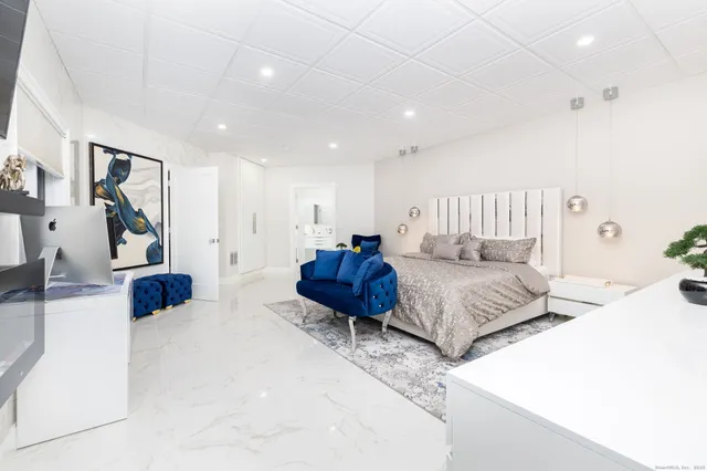 a spacious bedroom with a bed a couch and a view of living room