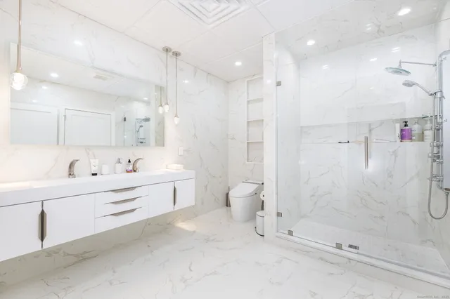 a bathroom with a bathtub shower sink vanity and toilet