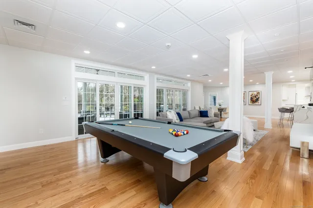 a room with pool table and wooden floor