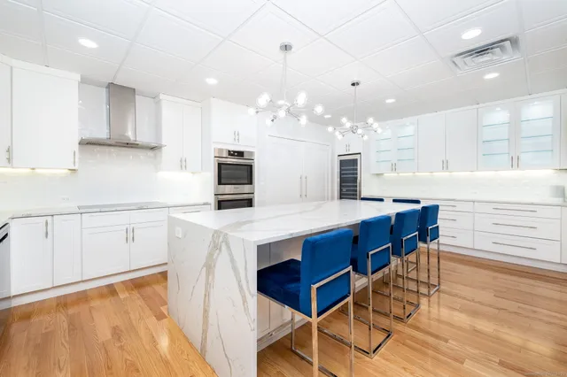 a kitchen with stainless steel appliances kitchen island granite countertop a table chairs sink and cabinets