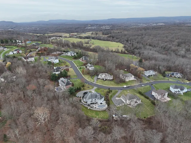 an aerial view of a house with yard and mountain view in back